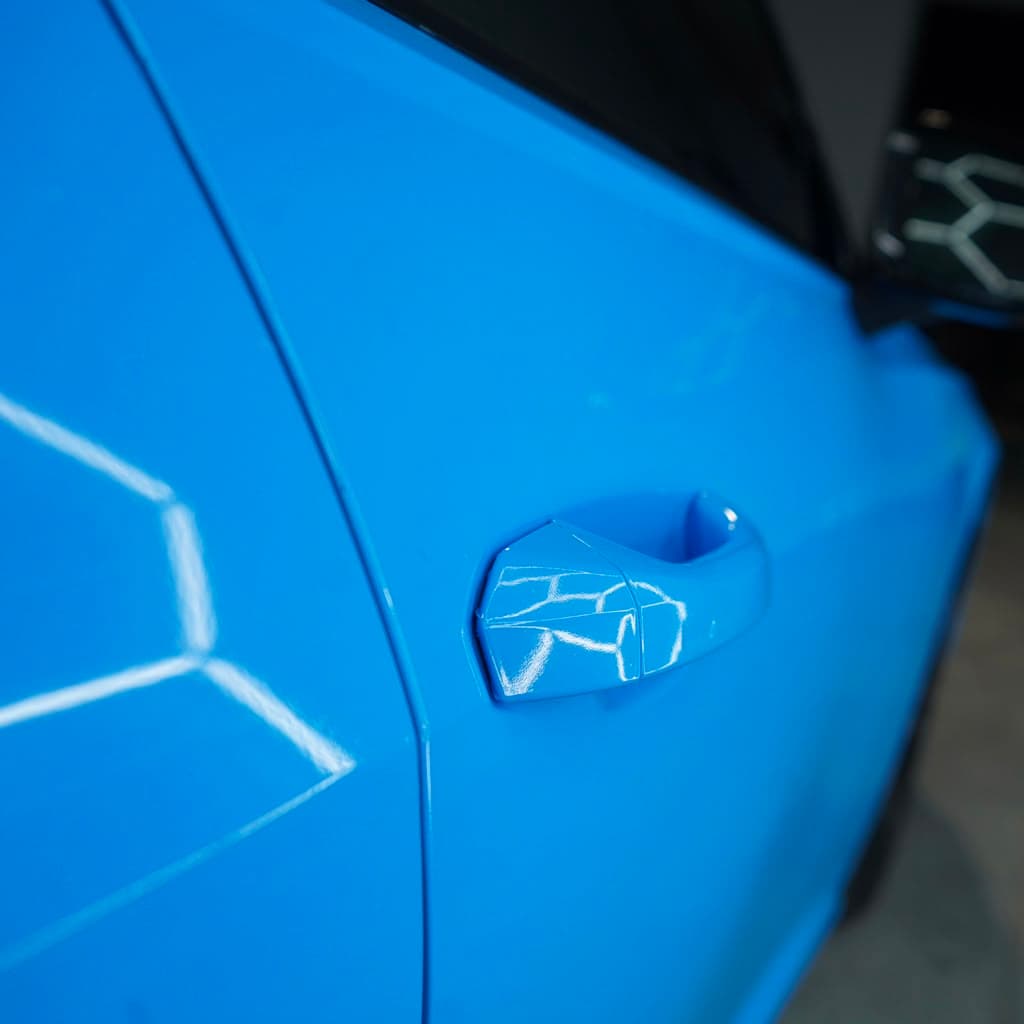 Macro close-up of the door handle finish on the completed blue wrap
