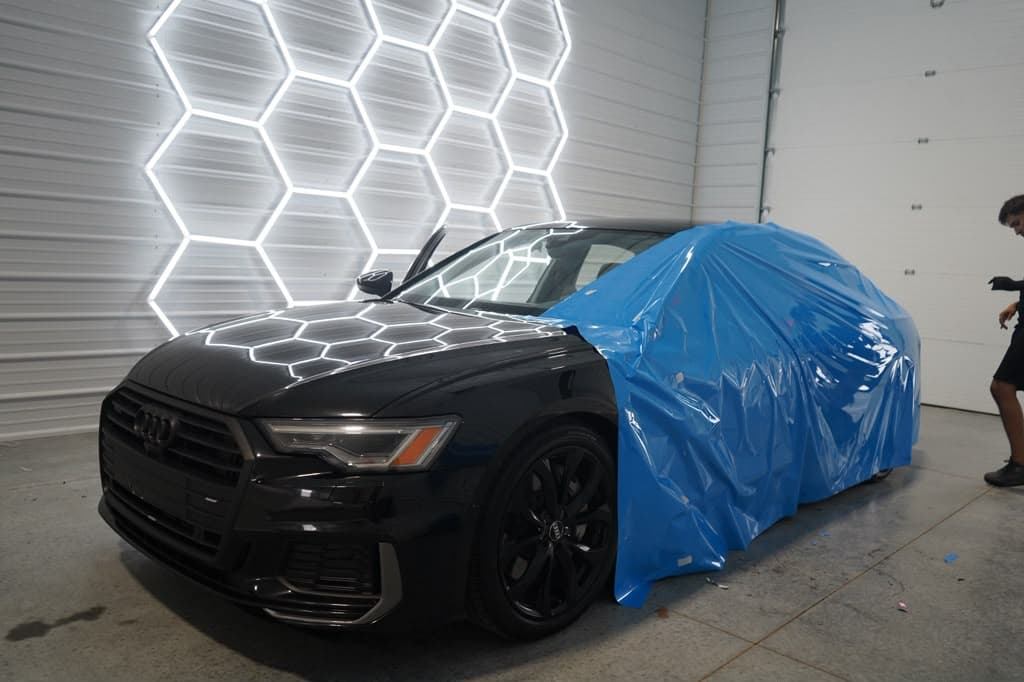 Audi A6 arriving at the shop, front end still under factory transport film